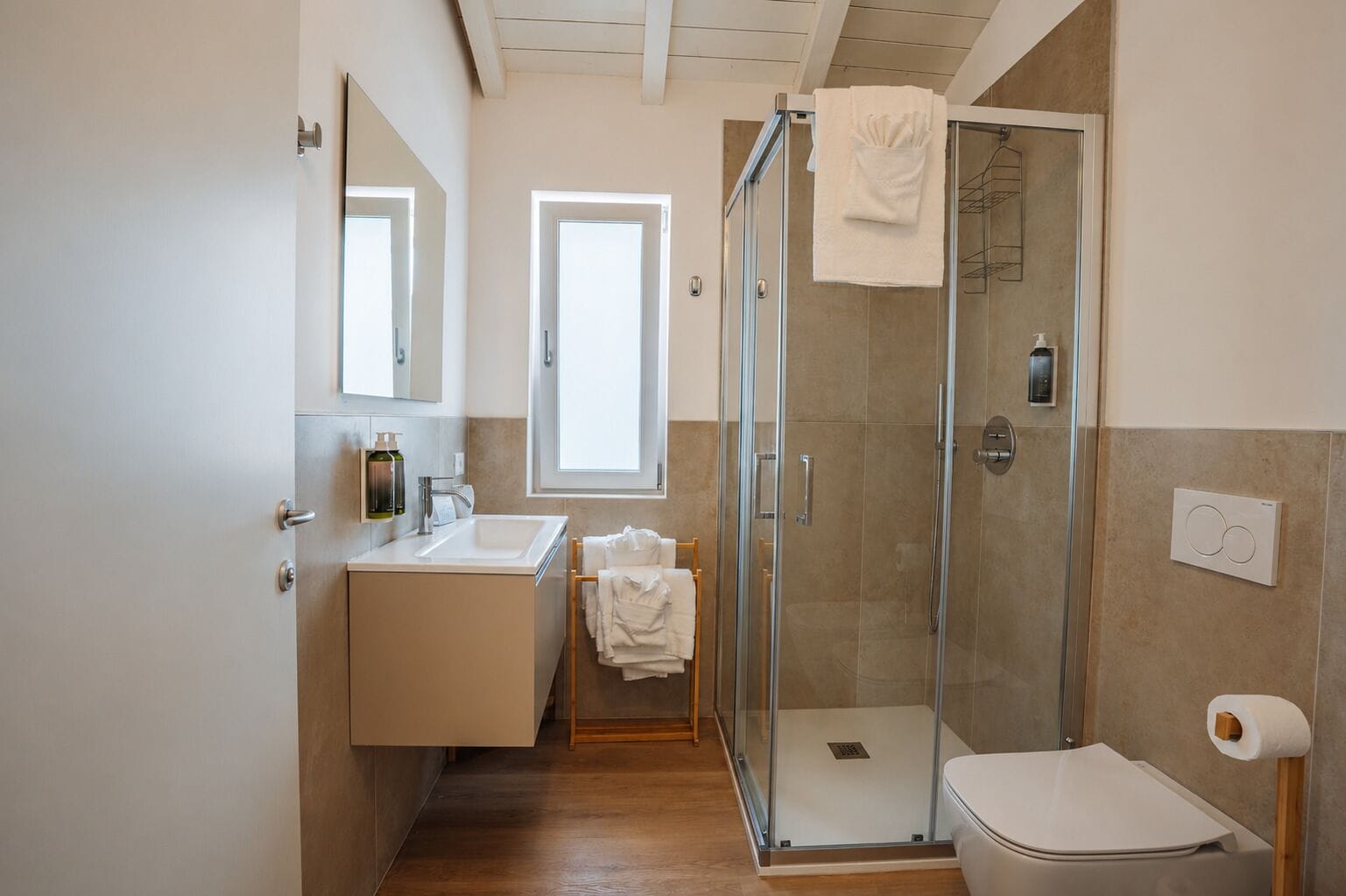 Ein modernes Badezimmer mit einer Duschkabine, einem Waschbecken mit Spiegel und einer Toilette.