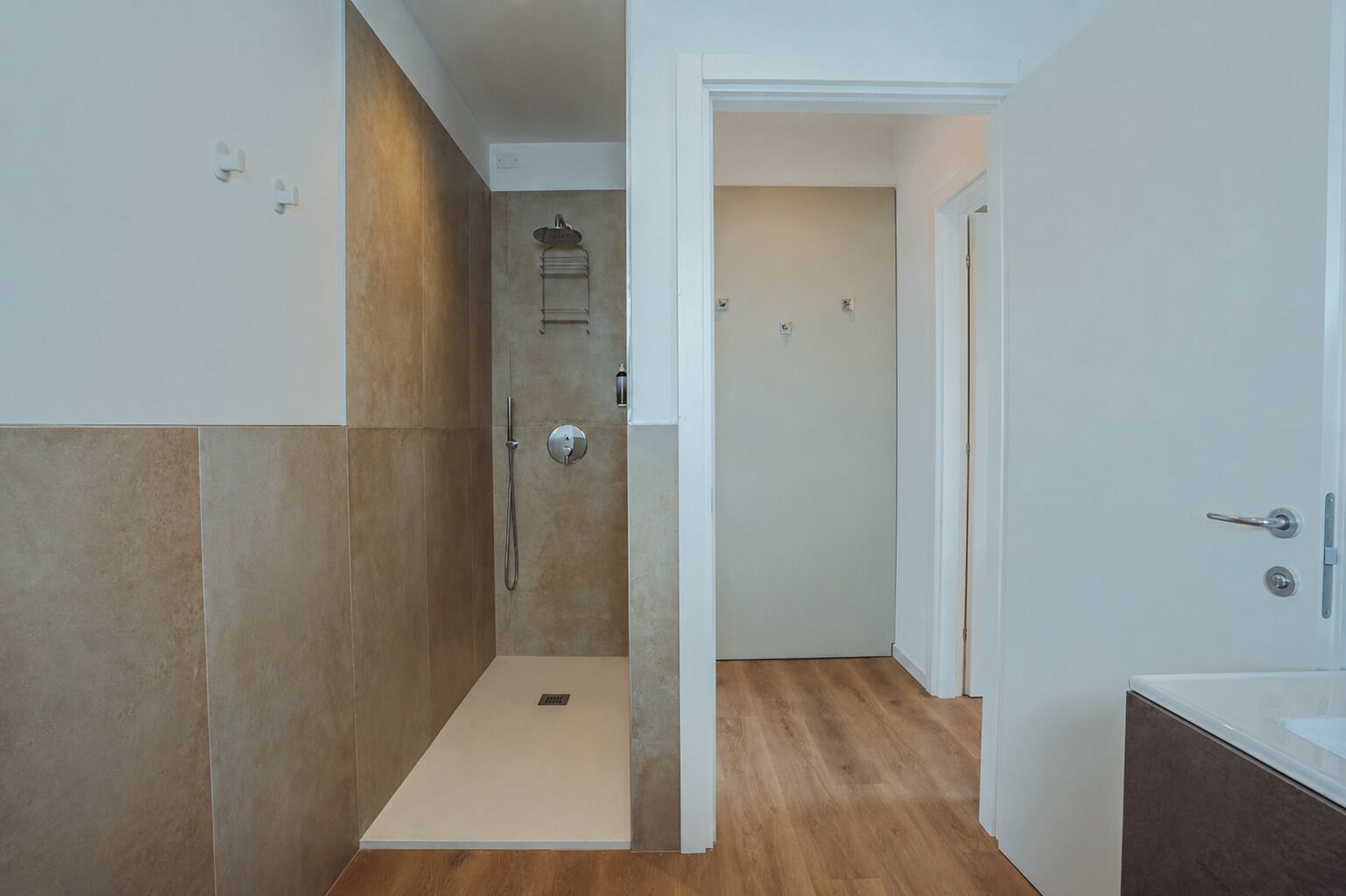 A modern bathroom with a shower, a toilet, and a sink.