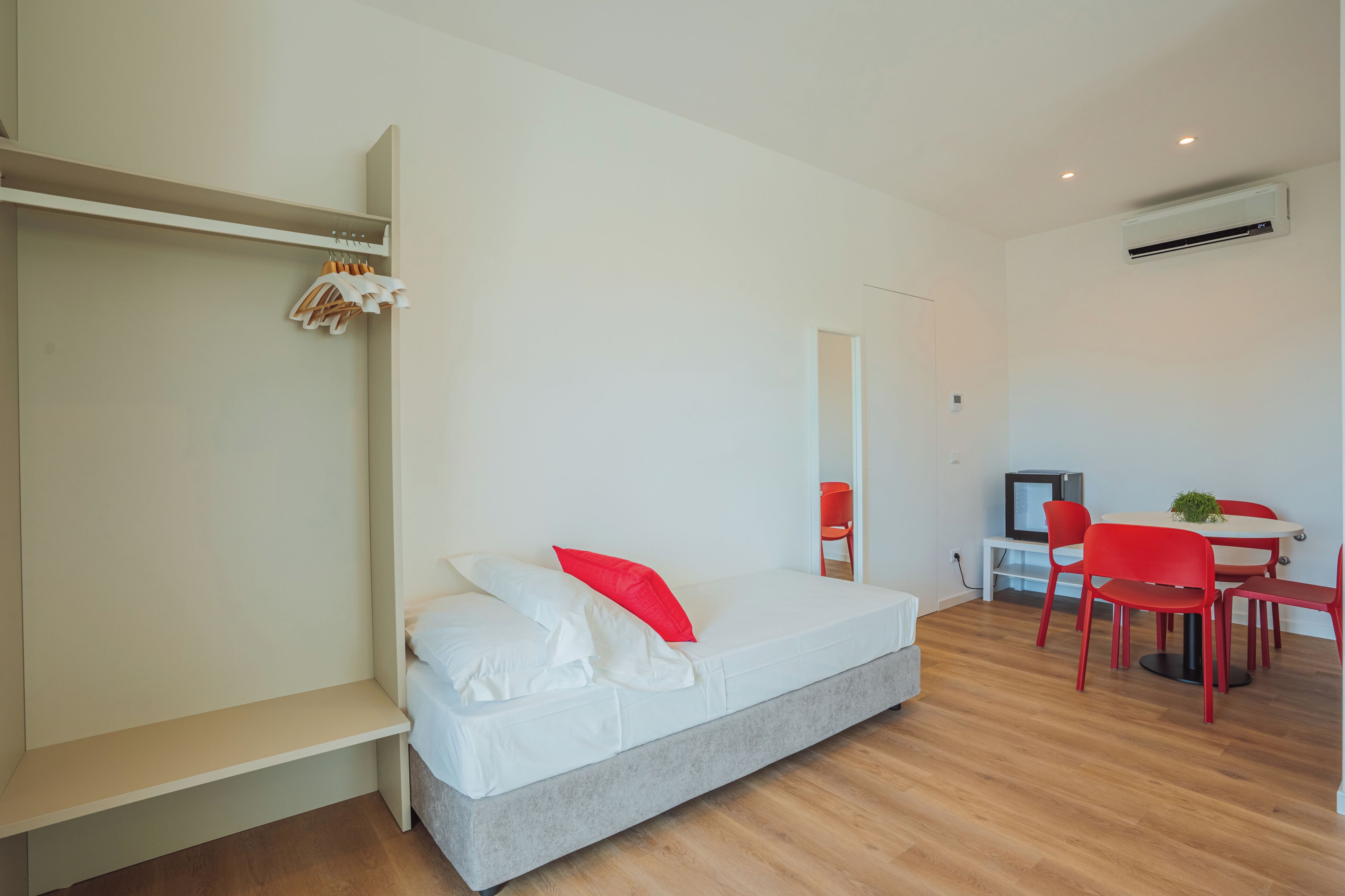 Een moderne kamer met een bed, een bureau en een stoel.