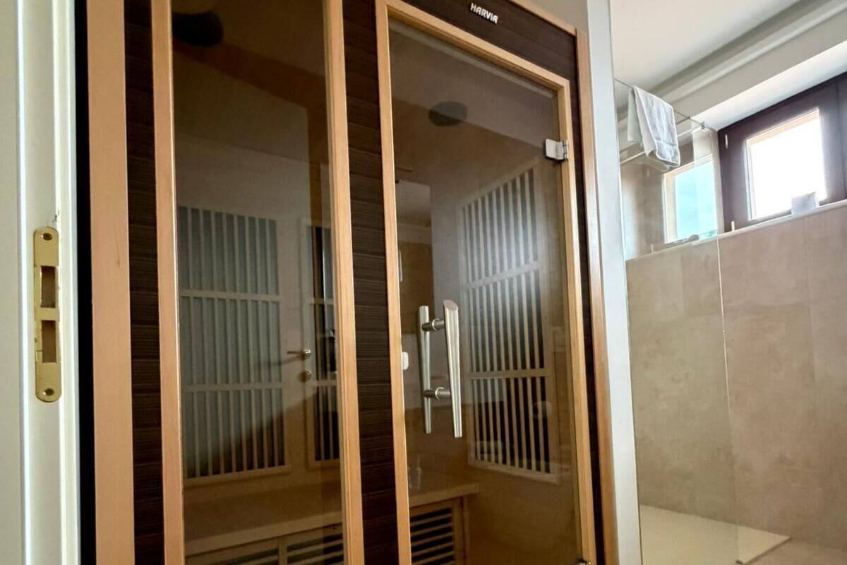 A room with a large sliding door, a shower area, and a window.