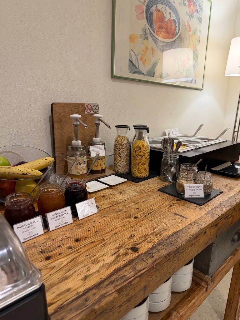 Un comptoir en bois sur lequel sont disposés des pots contenant des condiments, un panneau avec le symbole d’interdiction de fumer et, au mur, une œuvre d’art florale encadrée.