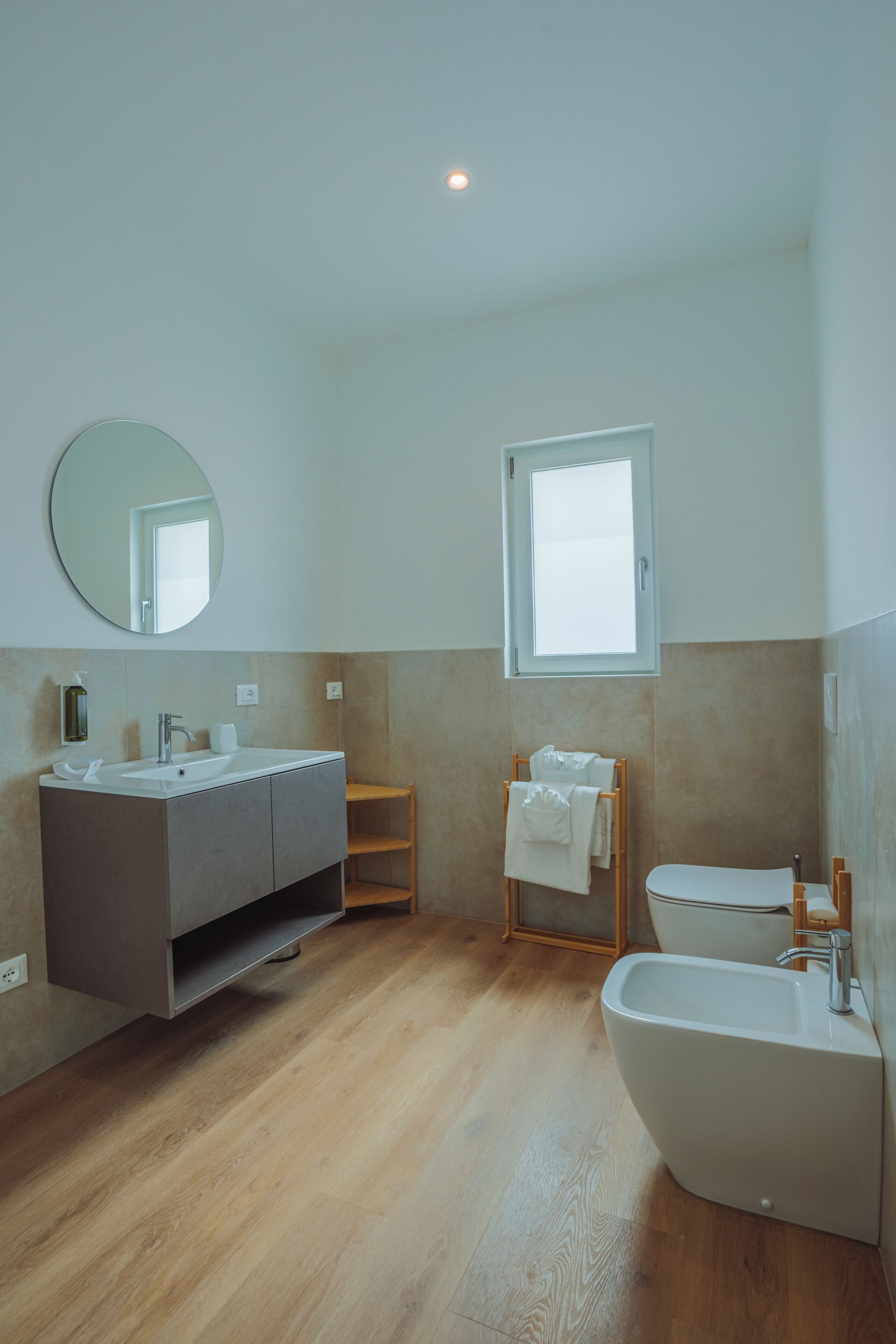 Een moderne badkamer met een wastafel, wasbak en een toilet met douchefunctie.