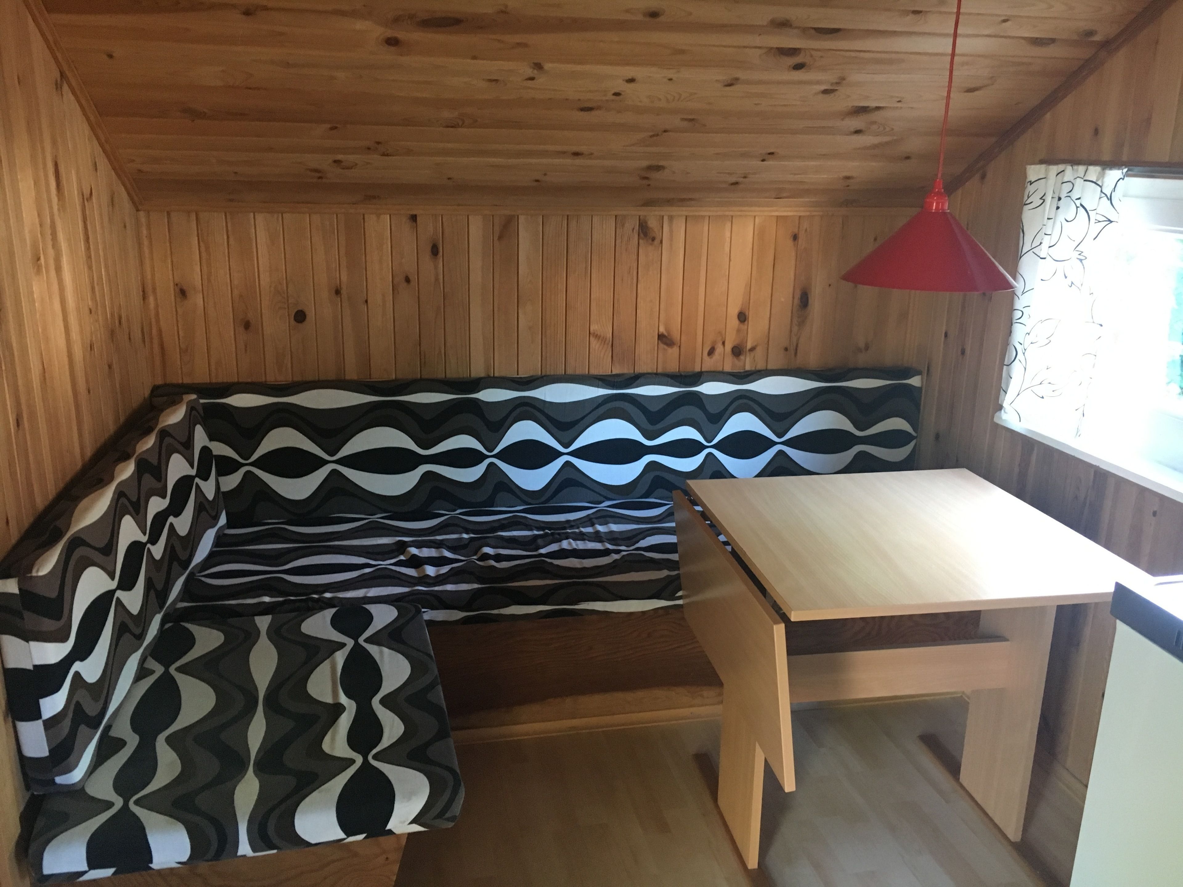 Un interior de madera con un banco y una mesa.