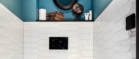 A bathroom with a white toilet, a black and white checkered floor, and a blue wall.