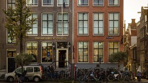 A historic building with a sign for The Hendrickshotel. It features a classic architectural style with multiple windows and a prominent entrance. - The Hendrick's Hotel (Amsterdam)