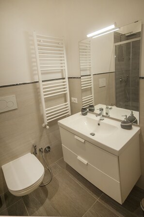 A bathroom with a white sink, mirror, and towel rack. - Guest House Vignola (Rome)