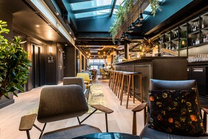 Un interior moderno con una zona de bar, asientos y una escalera.