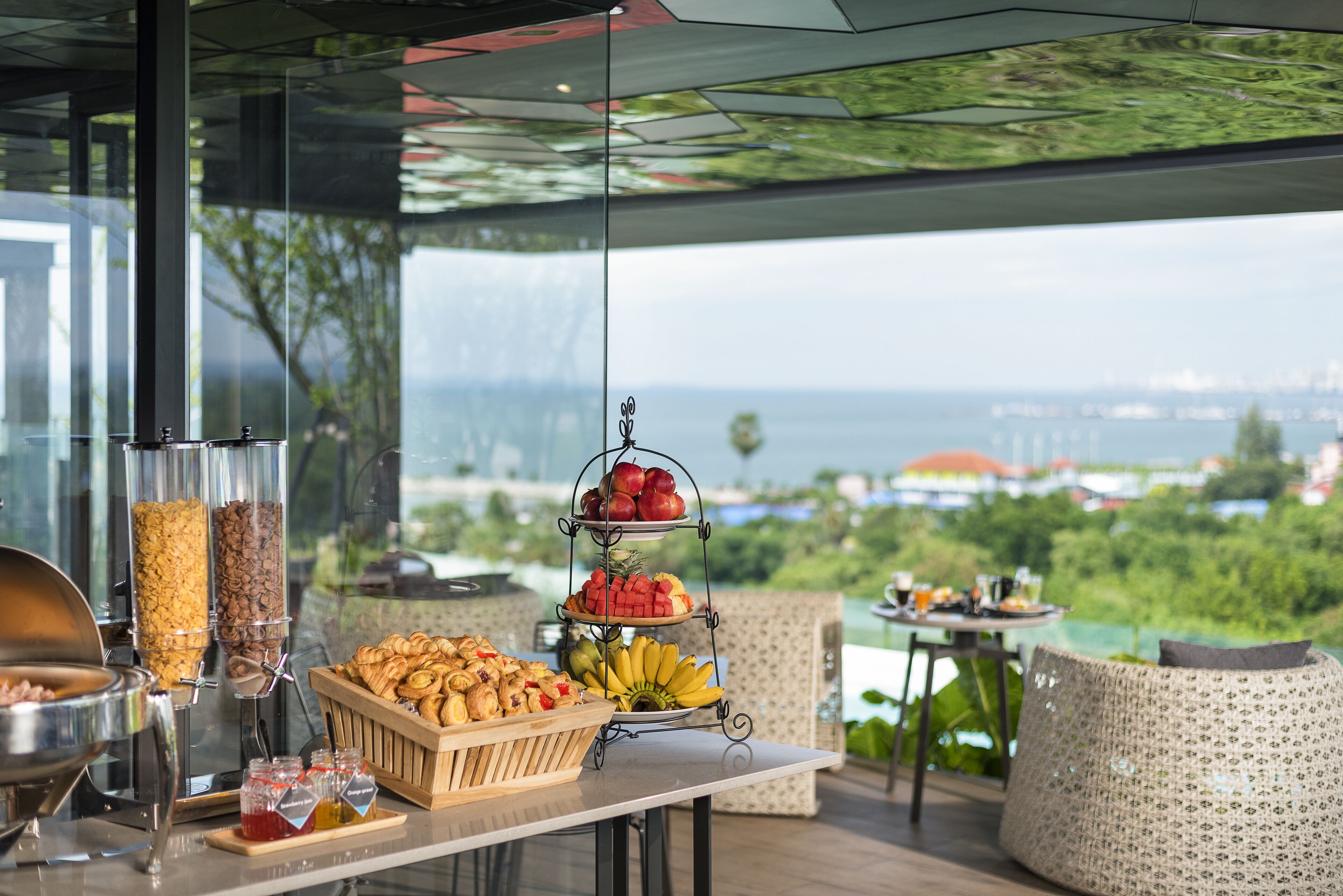 Un buffet proposant une variété de plats, avec en toile de fond une vue magnifique sur l’océan.