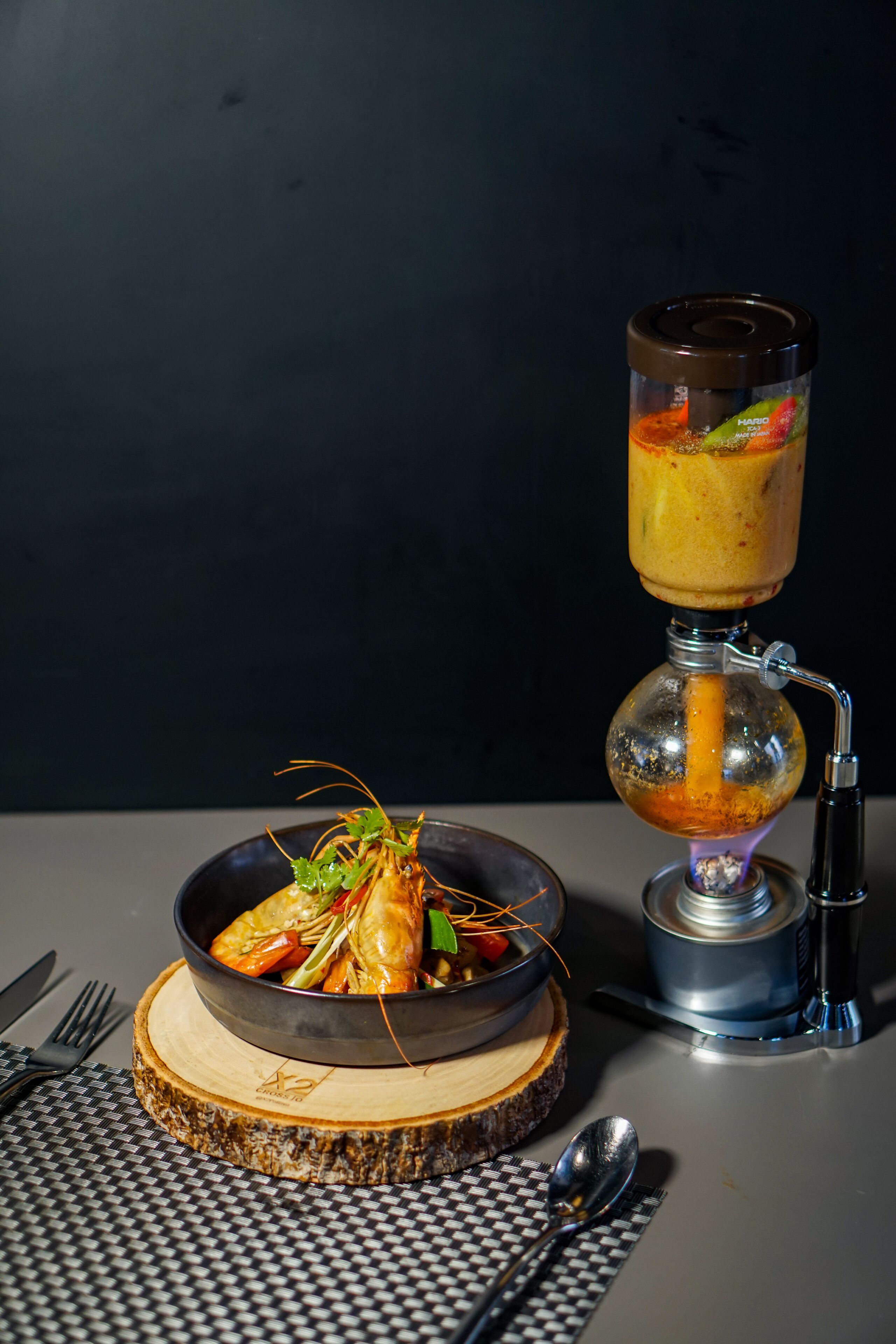 A dining table with a bowl of shrimp, a hookah, and a spoon.