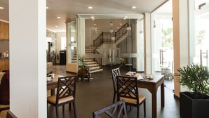 A spacious, well-lit interior with a dining area, a staircase, and a view of the outdoors. - Twenty-Two Weligambay (Weligama)