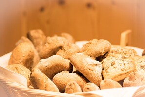 A basket of various breads and pastries. - Pension Maria (San Martino in Badia)