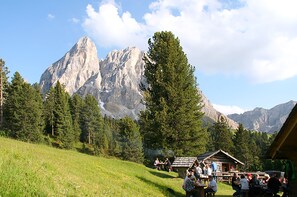 A mountain lodge with a dining area and guests. - Pension Maria (San Martino in Badia)
