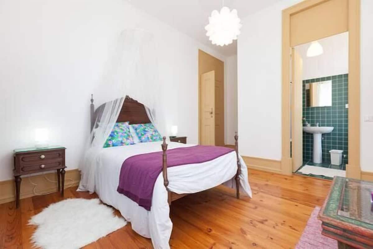 A bedroom with a bed, bedside table, and a nightstand.