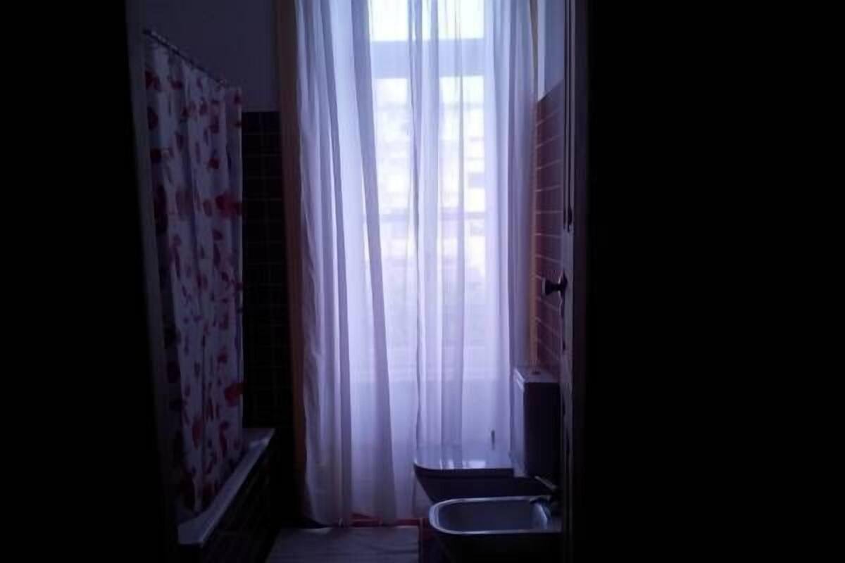 A bathroom with a shower, a sink, and a toilet.