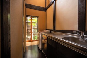Un baño estrecho con un lavamanos y una ventana.