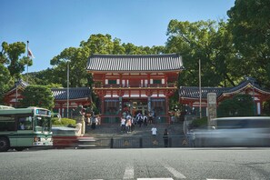 A traditional Japanese building with a prominent entrance, steps leading up to it, and a clear sky in the background. - AKARI Kyoto Gion (Kyoto)