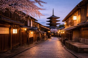 A traditional Japanese street with wooden buildings, a pagoda, and cherry blossoms. - AKARI Kyoto Gion (Kyoto)