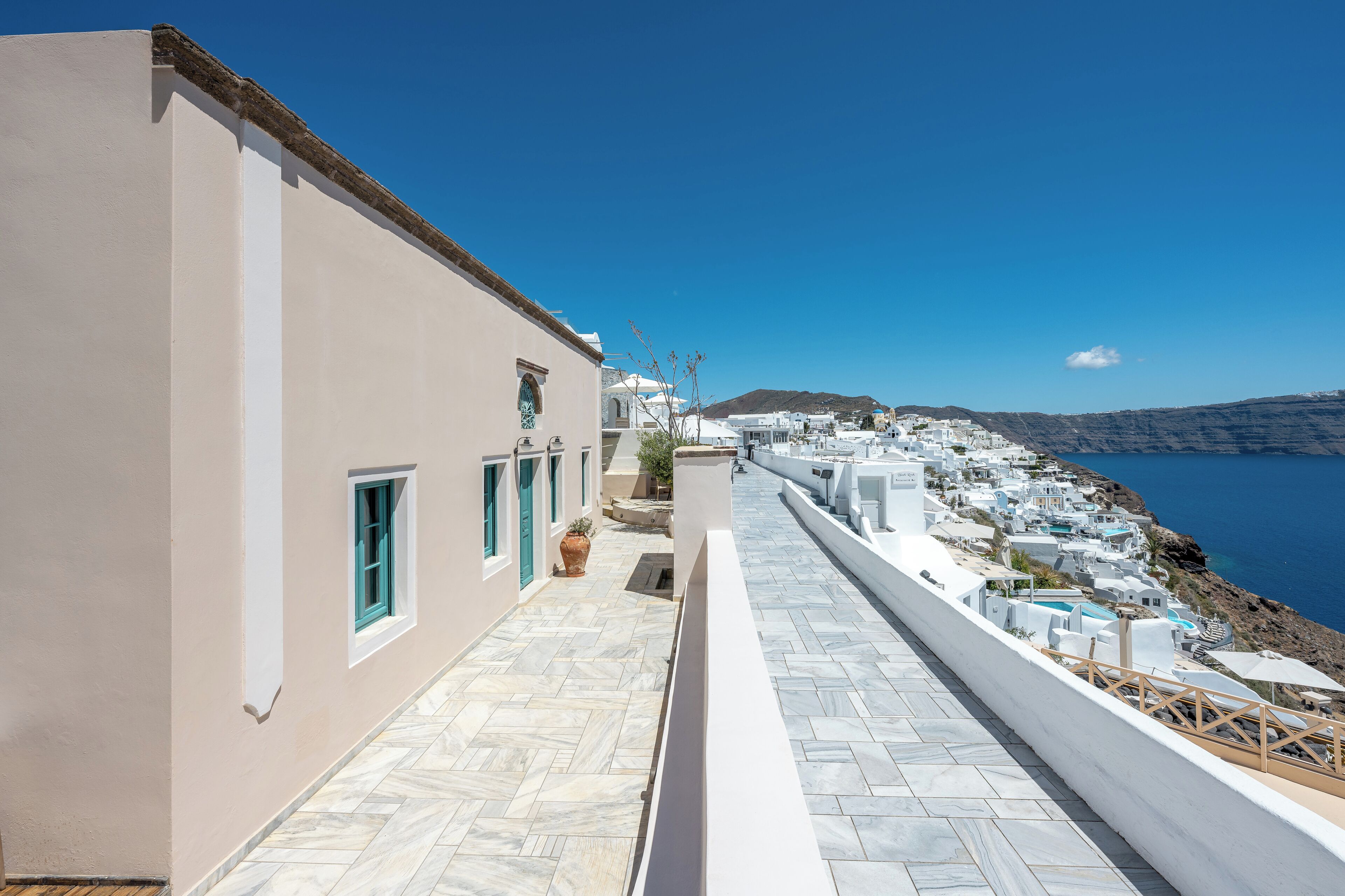 A coastal building with a tiled walkway and a view of the sea.