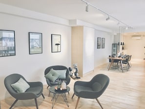 Una sala de estar moderna con comedor, que incluye un juego de sofá, una mesa de centro y una mesa de comedor con sillas.