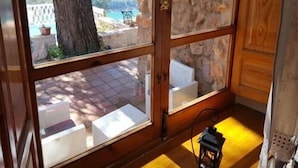 Una habitación con un amplio ventanal, suelo de madera y pared de piedra.