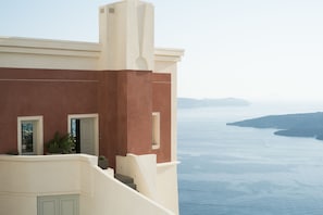 A coastal building with a staircase leading to a balcony overlooking the sea.