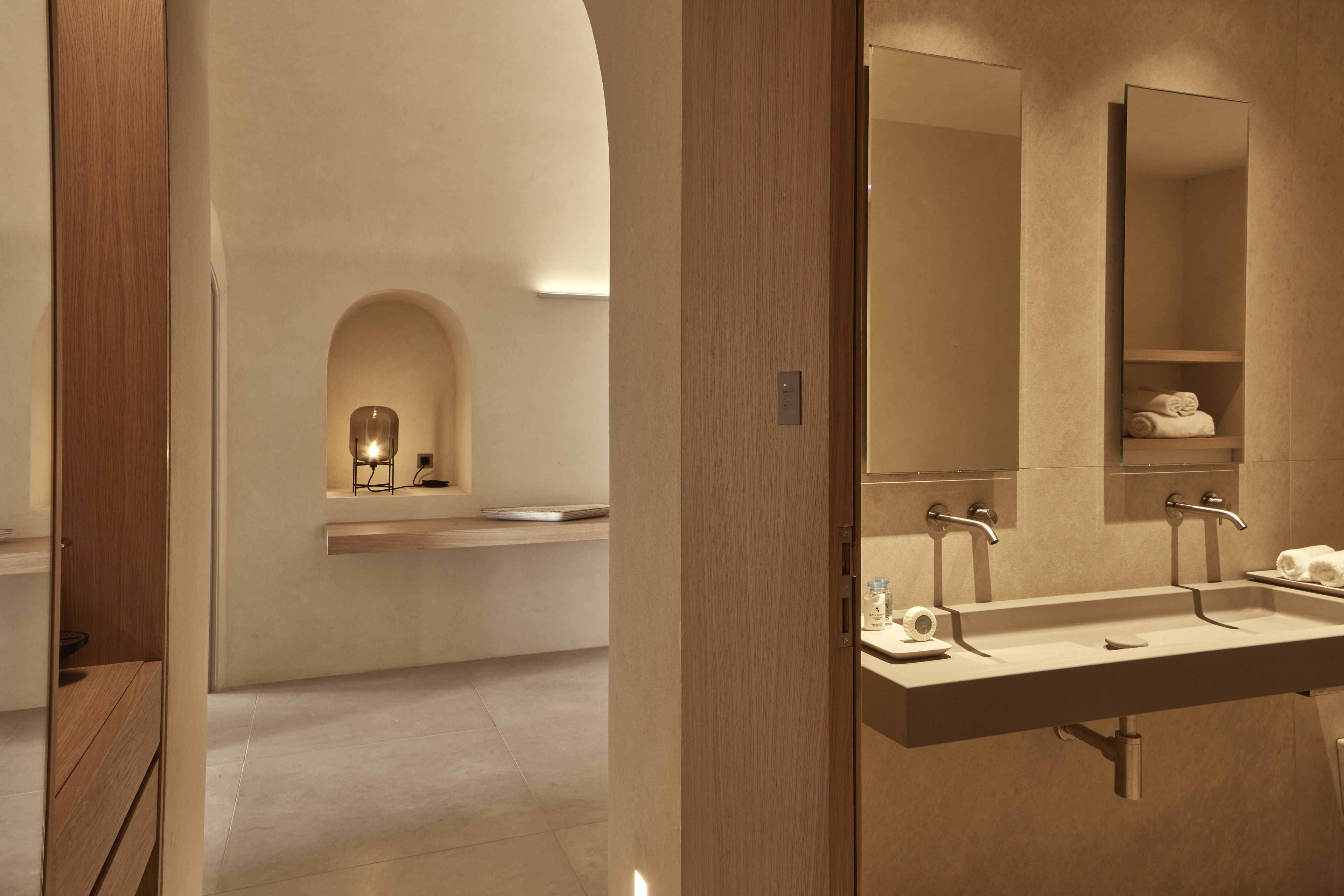 Un baño moderno con un espejo grande, dos lavamanos y un mueble de tocador de madera.