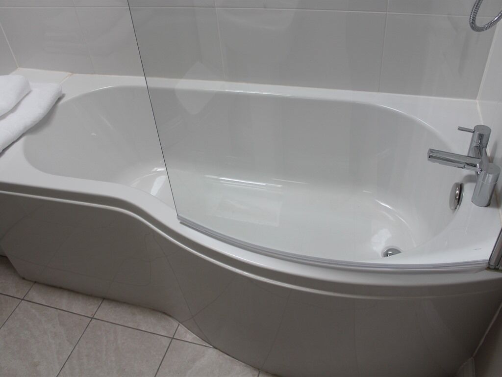 Un bagno moderno con una vasca freestanding, un angolo doccia e un water.