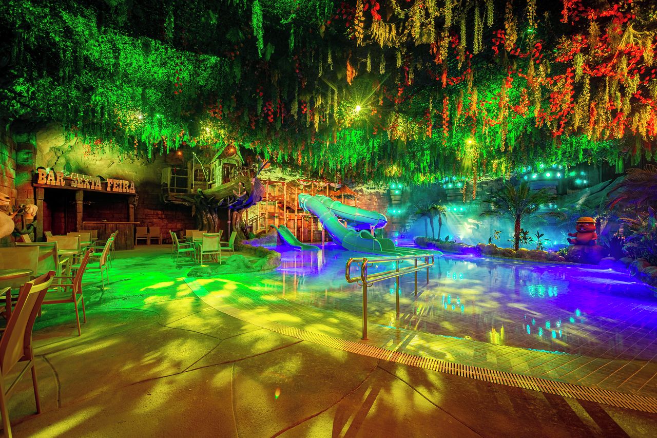 Un área de piscina interior con tobogán, asientos y un bar llamado 'BAR SEXA FEIRA'.