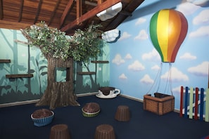 Ein Zimmer mit Baum, Heißluftballon und Hockstühlen.