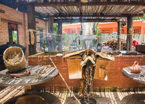 Un espace de restauration extérieur de style rustique, avec un mur en briques, des poutres en bois et un toit de chaume.