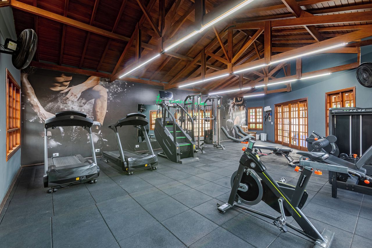 A gym with treadmills, elliptical machines, and weight equipment.