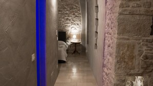 A narrow hallway with stone walls and a wooden floor. - GRAFFITI LIVING-SANTA RITA (Corato)