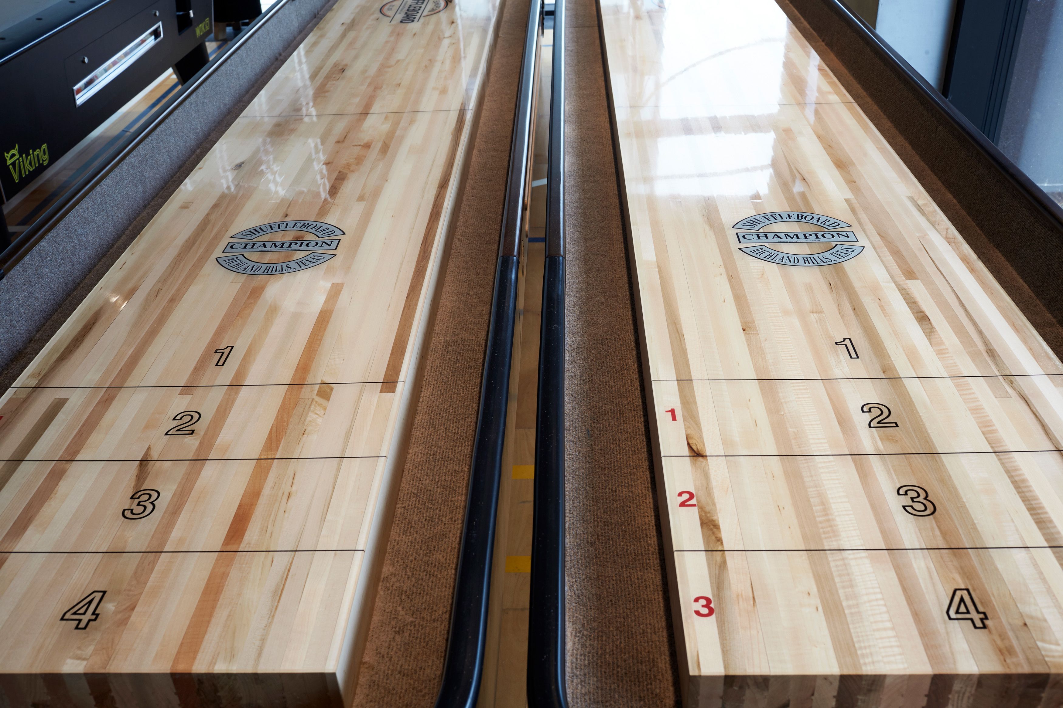 A shuffleboard table with numbered scoring areas and a logo indicating a championship event.