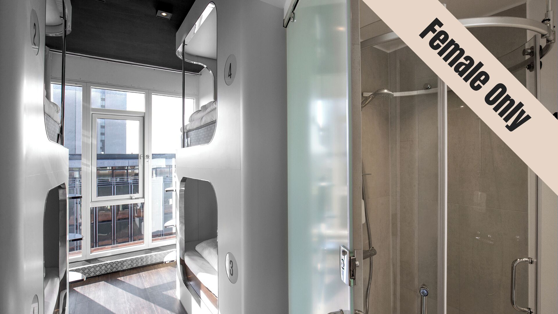 A modern interior with a glass shower enclosure, a view of the city through large windows, and a number indicating a specific room.