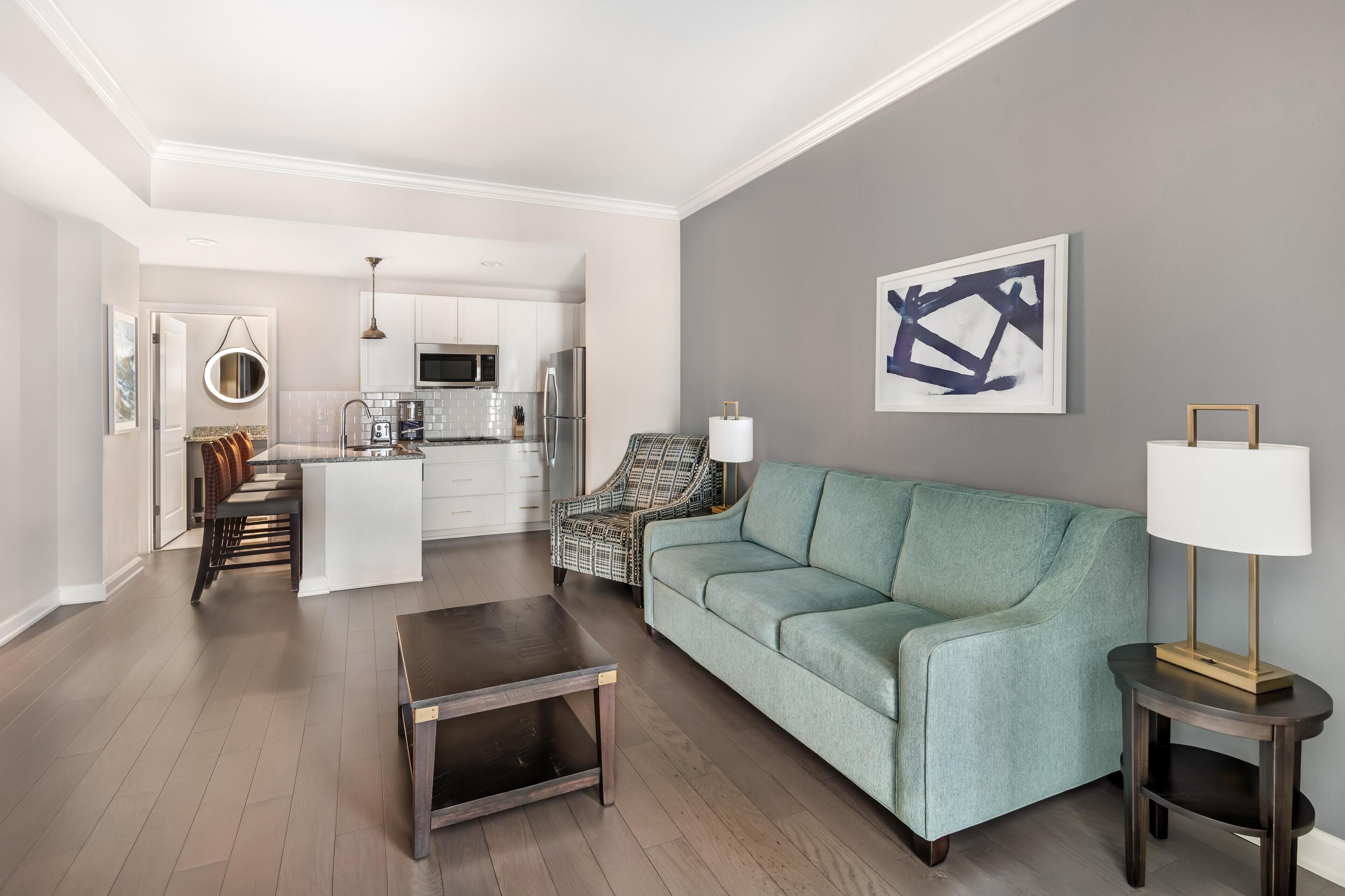 A modern living room with a sofa, coffee table, and a lamp.