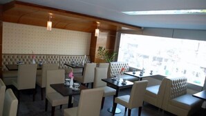 Un restaurante con techo alto, asientos acolchados y vistas amplias a través de grandes ventanales.