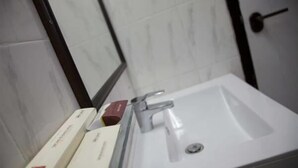 A bathroom with a white sink, a mirror, and two boxes on the counter.