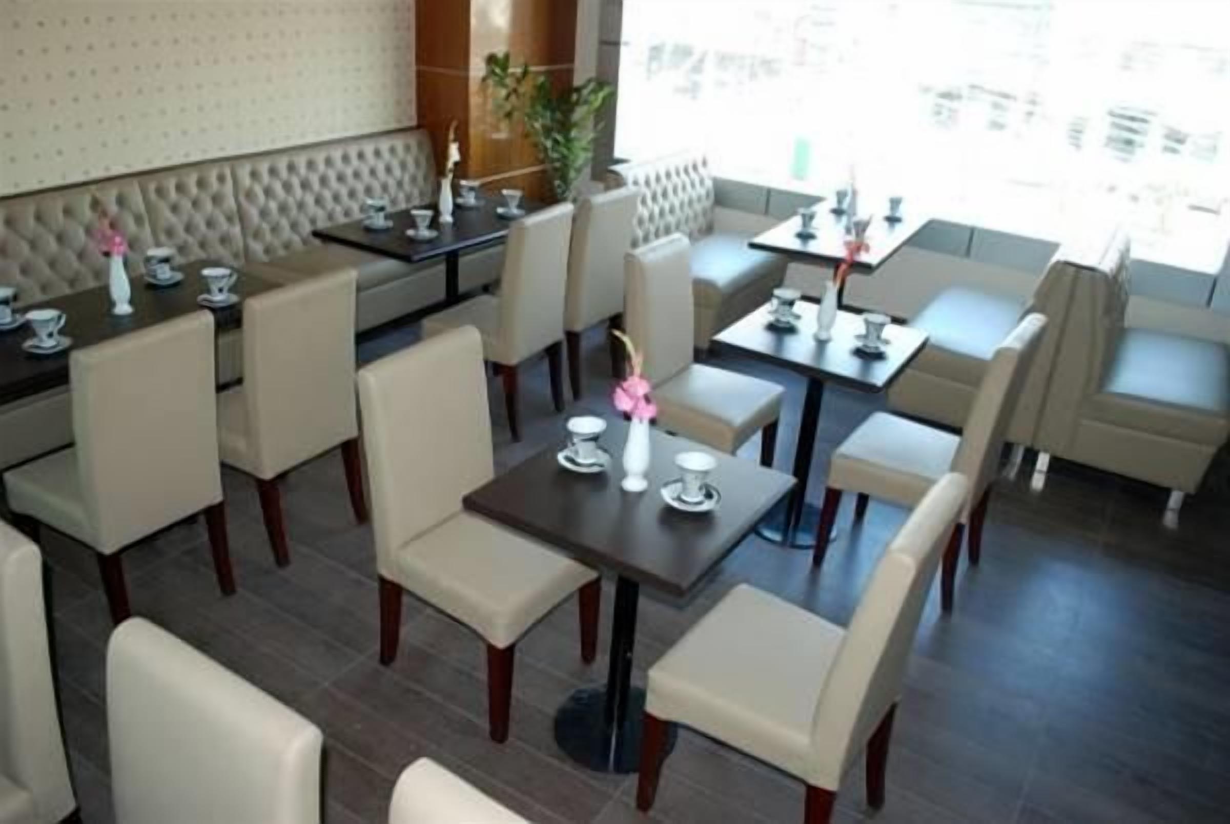 Moderni ravintola, jossa on sekä erillisiä istuinosastoja että tavallisia pöytiä.
