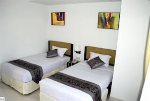 A hotel room with two single beds, each with a headboard, bedside tables, and a telephone. - Orchid Business Hotel (Chittagong)