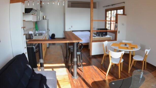 A compact living space with a kitchenette, a dining area, and a seating area. - Lofts Parque Mirador Cerro Alegre (Valparaiso)
