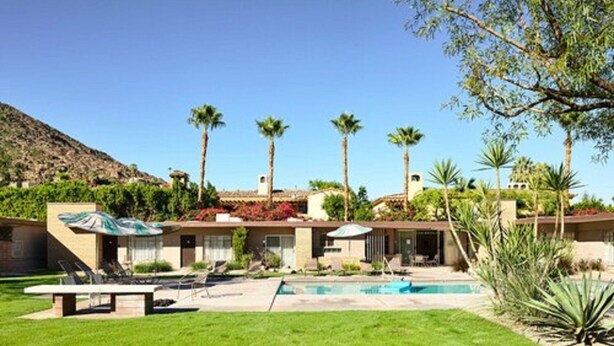A residential property with a swimming pool, lounge chairs, and palm trees. - The Hideaway - 21 and Over - A Town & Desert Boutique Hotel (Palm Springs)