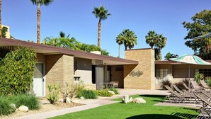 A modern building with a stone facade, palm trees, and a well-maintained lawn. - The Hideaway - 21 and Over - A Town & Desert Boutique Hotel (Palm Springs)