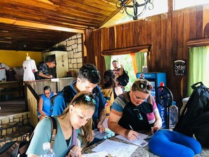 A group of people seated at a table, engaged in writing or signing documents. - Mayan Hills Resort (Copan Ruinas)