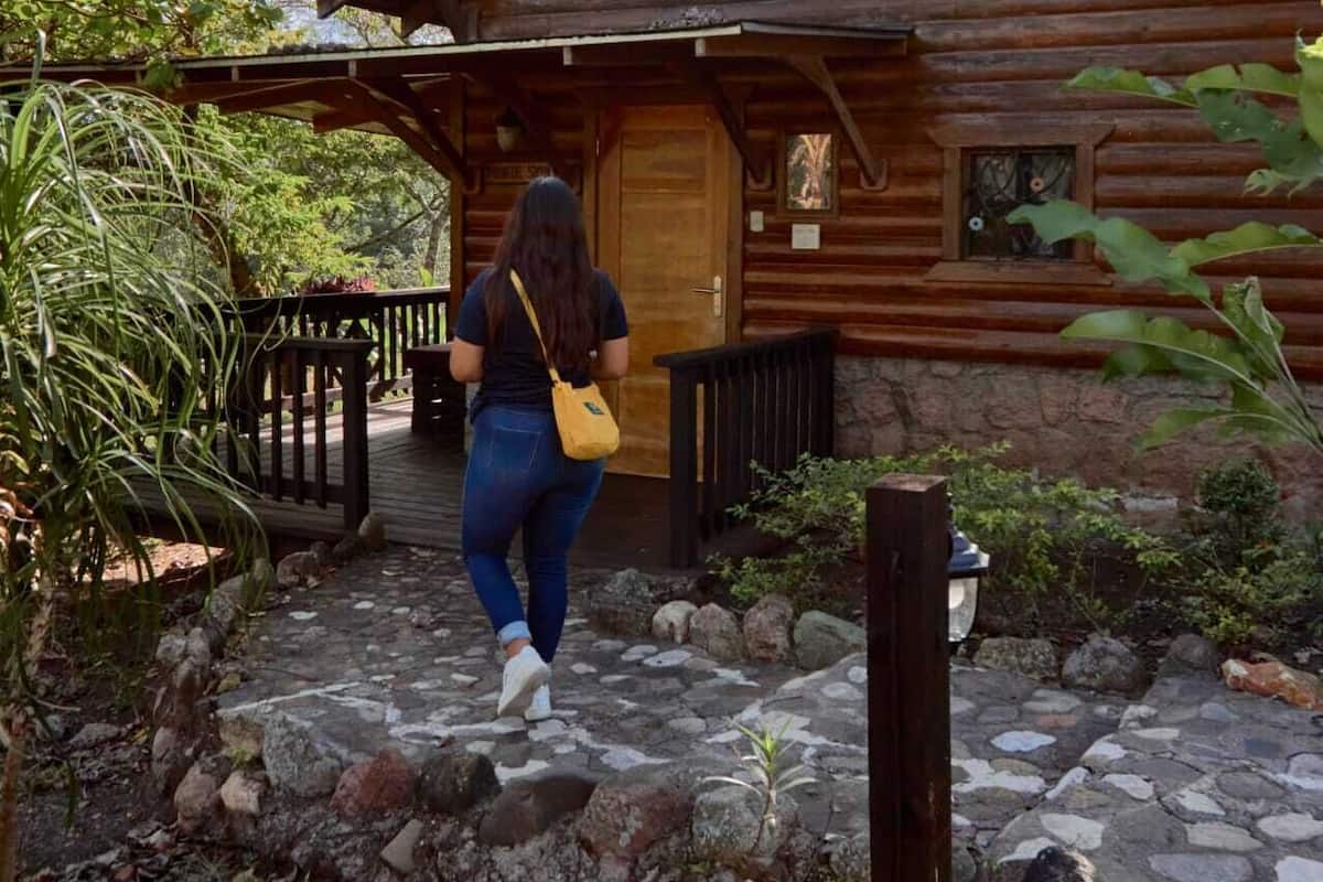 Uma cabana de madeira com um caminho de pedra que leva à entrada.