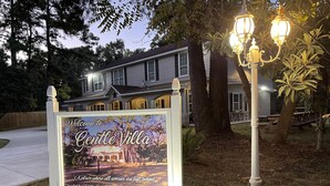 Señal de bienvenida a Gentle Villa, una casa de vacaciones, con números de contacto para reservas.