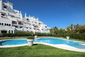 Ein modernes Hotel mit Schwimmbad, üppigem Rasen und mediterranem Stil.