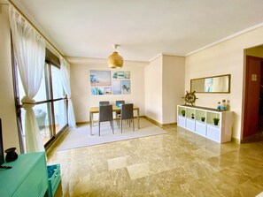 Ein Essbereich mit Tisch, Stühlen, Deckenventilator und Wandbildern.