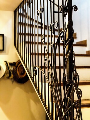 A staircase with ornate metal railings and a wooden handrail. - Mansion - Correns (Correns)
