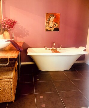 A bathroom with a freestanding bathtub, a white sink, and a wicker basket. - Mansion - Correns (Correns)