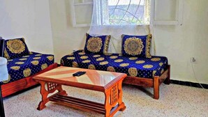 A room with two sofas, a small wooden table, and a window with a view. - Superb F2 Apartment With INCREDIBLE Panoramic View (Souk El Ténine)